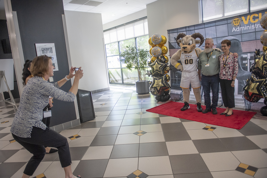 Employees taking photos with Rodney the Ram